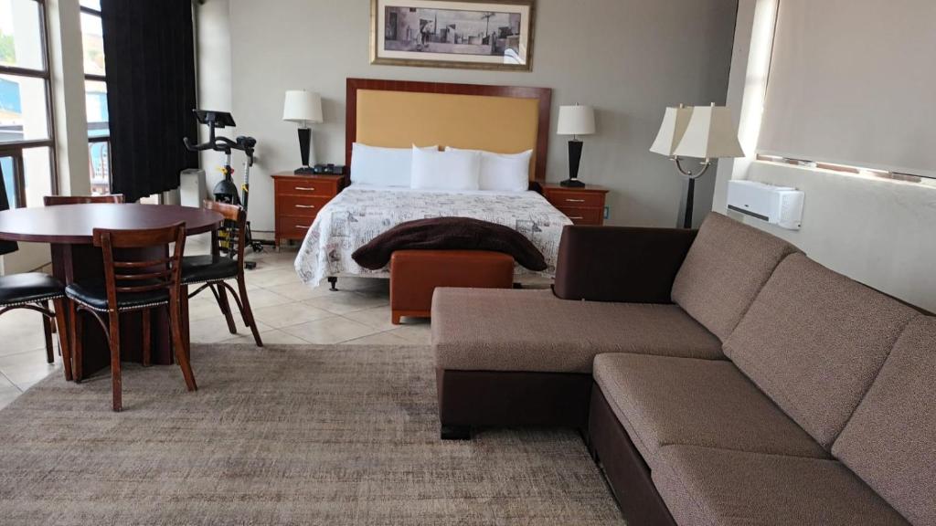 ein Hotelzimmer mit einem Bett, einem Sofa und einem Tisch in der Unterkunft Panoramic Penthouse Downtown (Free Parking) in Tijuana