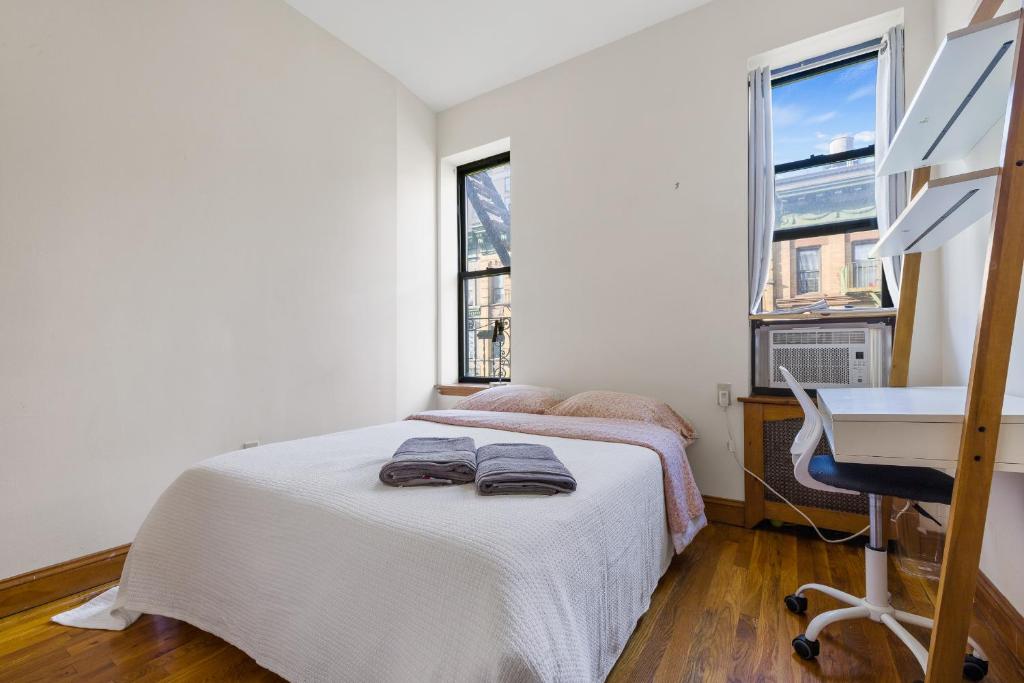 Schlafzimmer mit einem Bett, einem Schreibtisch und einem Fenster in der Unterkunft Central Living at Columbia university in New York