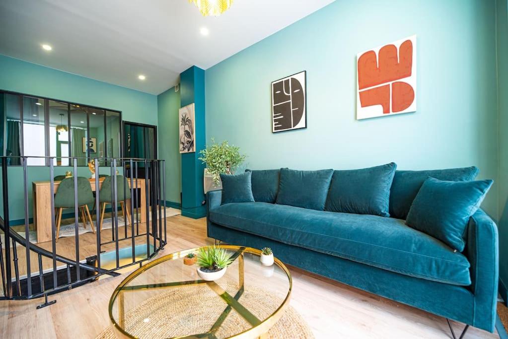 un salon avec un canapé bleu et une table dans l'établissement Beautiful Apartment close to Eiffel Tower, à Paris