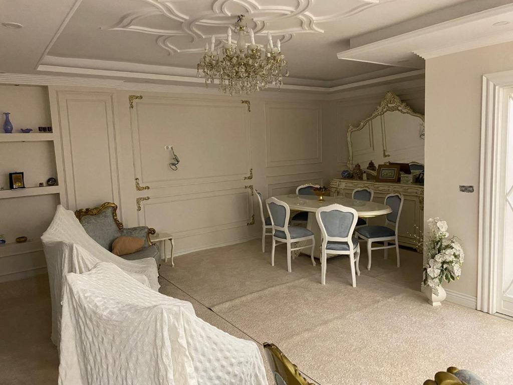 ein Esszimmer mit einem Tisch, Stühlen und einem Kronleuchter in der Unterkunft Luxury Flat / Lux Daire Cizre in Jesıret ibn Omar