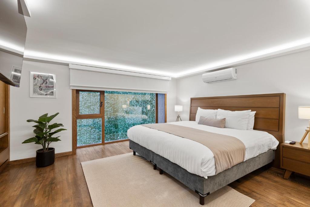 a bedroom with a large bed and a window at Casa Niza Suites in Mexico City