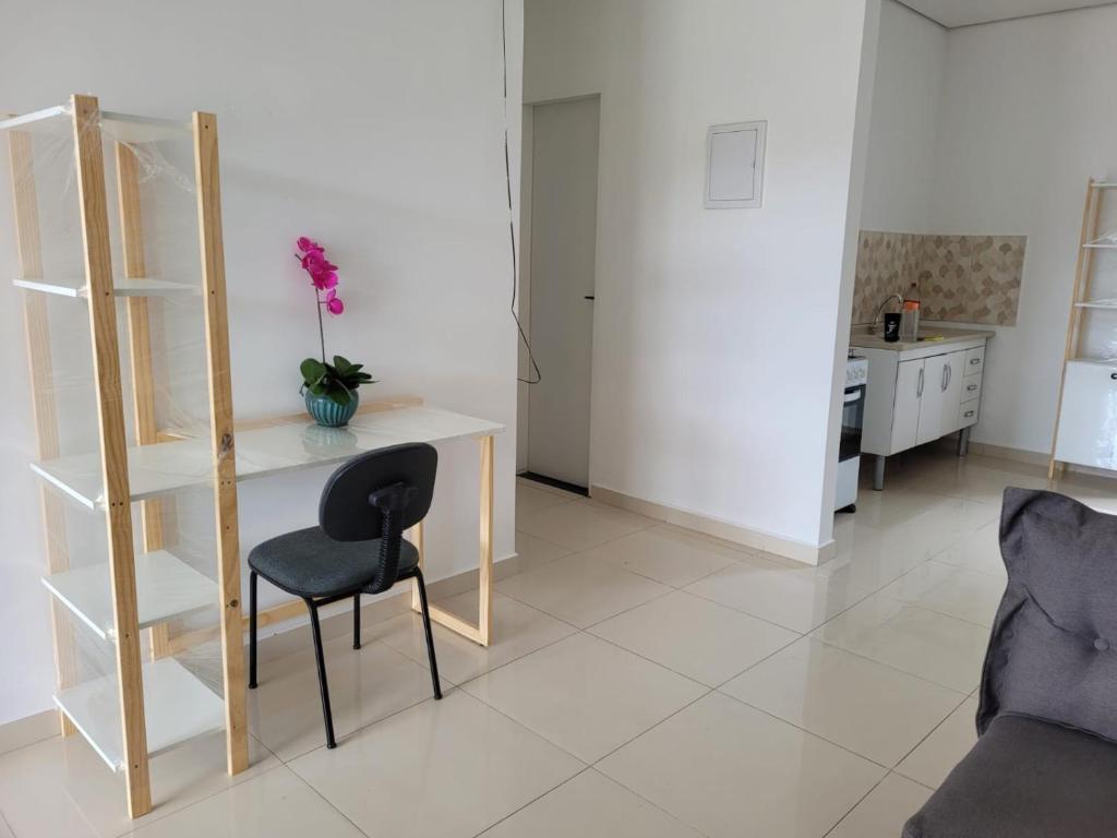een woonkamer met een bureau en een stoel bij Apartamento com garagem no maior setor comercial de BV in Boa Vista