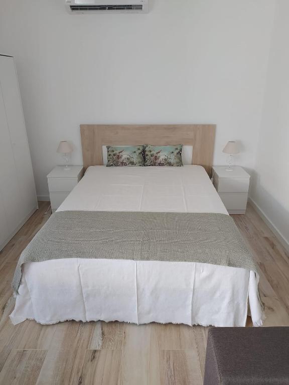 a bedroom with a large bed with two night stands at Casinha2 in Amieira