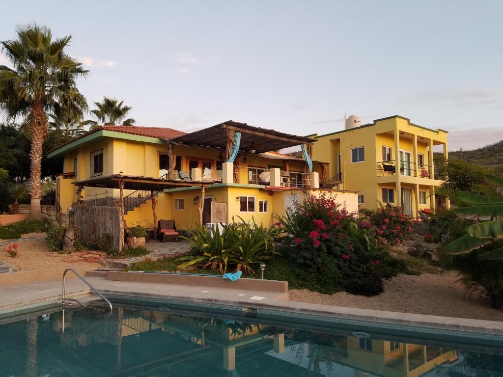 uma casa com piscina em frente a uma casa em Casa Flores Casitas em Todos Santos