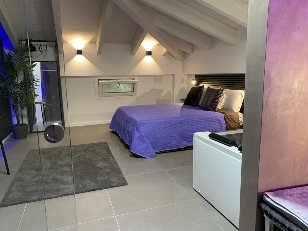 a bedroom with a purple bed and a bathroom at Villa Primodì in Bologna