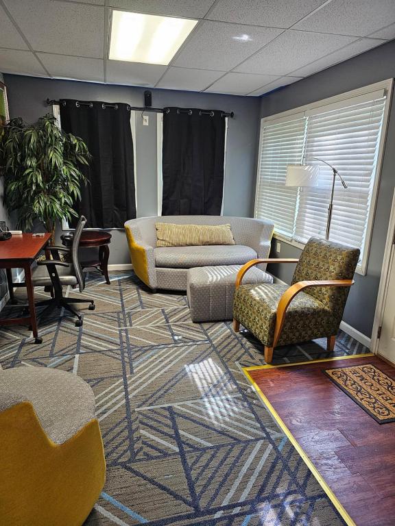 a living room with couches and chairs on a rug at Tranquility & Minutes from DTW in Romulus