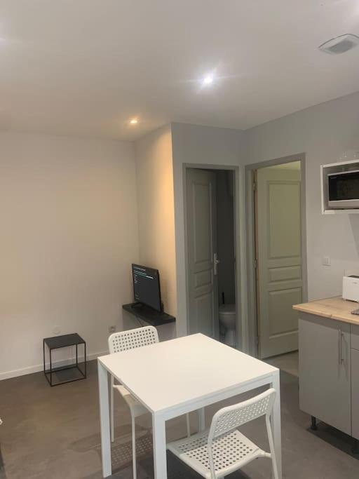 a kitchen with a white table and chairs in a room at Appartement centre ville T2 001 in Roanne