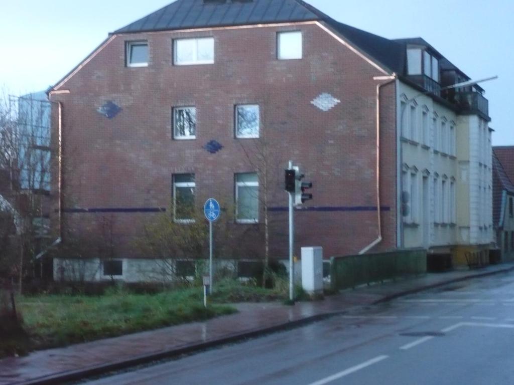 a large red brick building on the side of a street at Zimmervermietung Hartl in Barmstedt