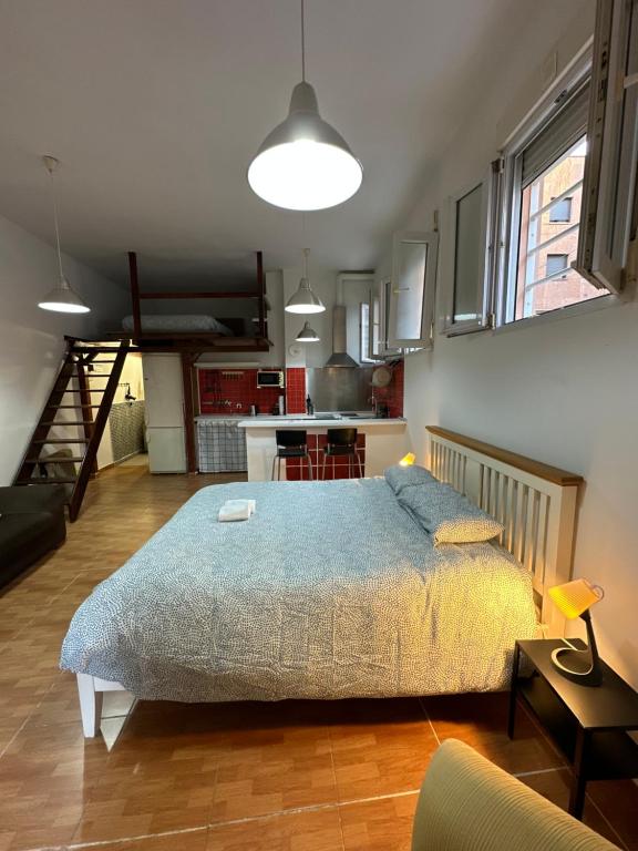 a bedroom with a bed and a kitchen at Apartamentos Berruguete in Madrid
