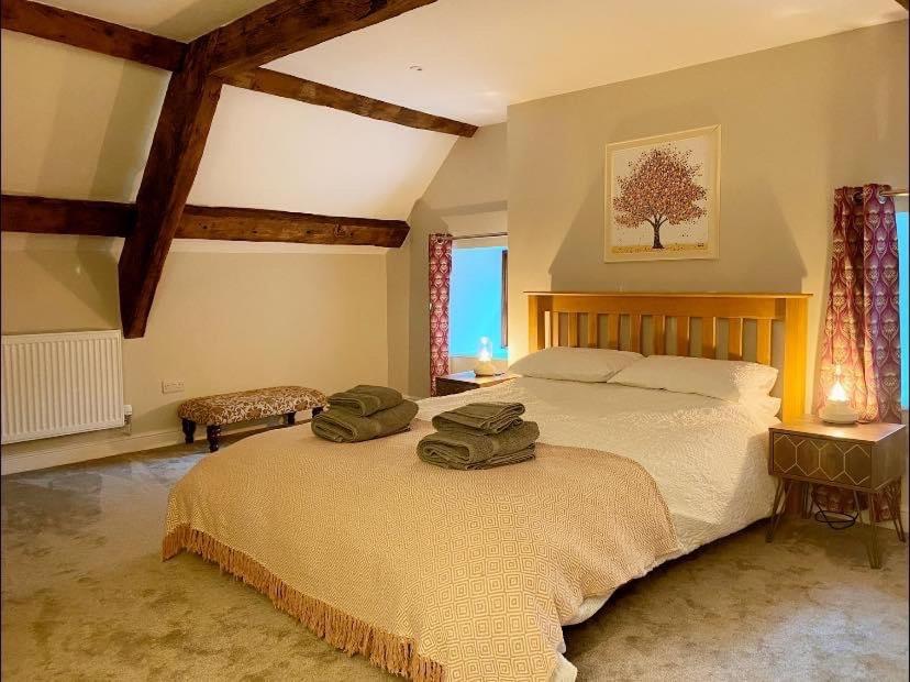a bedroom with a large bed with two green towels on it at The Cottage at Sychnant Farm in Talgarth