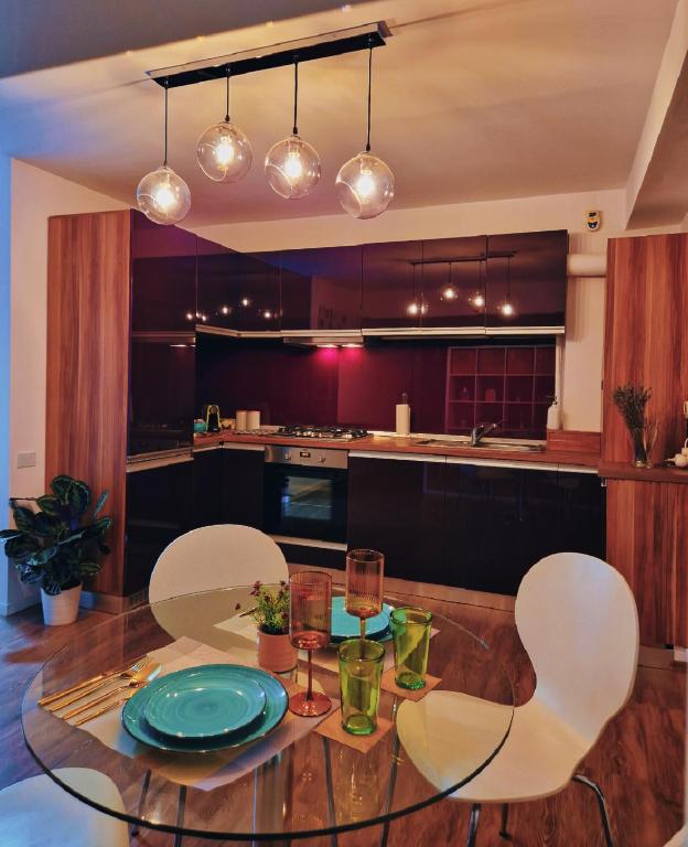 a kitchen with a glass table and white chairs at Self Check-IN Free Parking Near Metro Stations and BUS WestSide Studio S6 in Bucharest