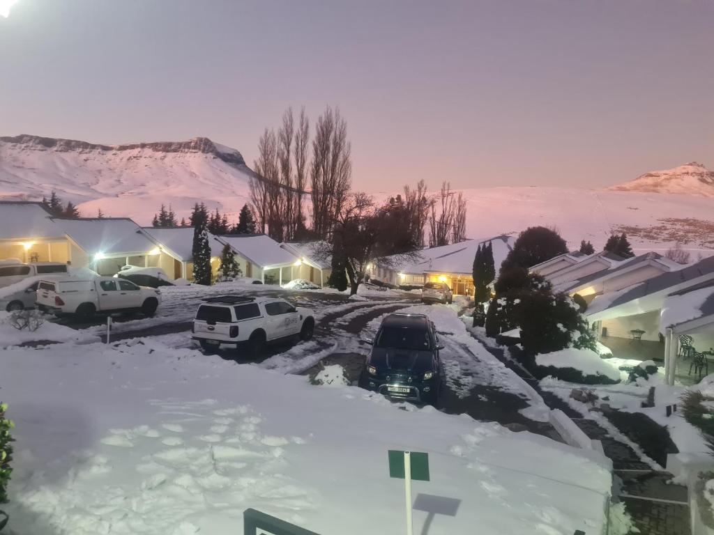 un pueblo cubierto de nieve con coches aparcados en la nieve en mountain shadows hotel, en Elliot