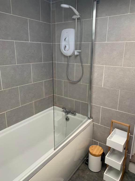 a bathroom with a shower with a white tub and a sink at Cosy Cottage, Nr Betws y Coed. in Llanrwst