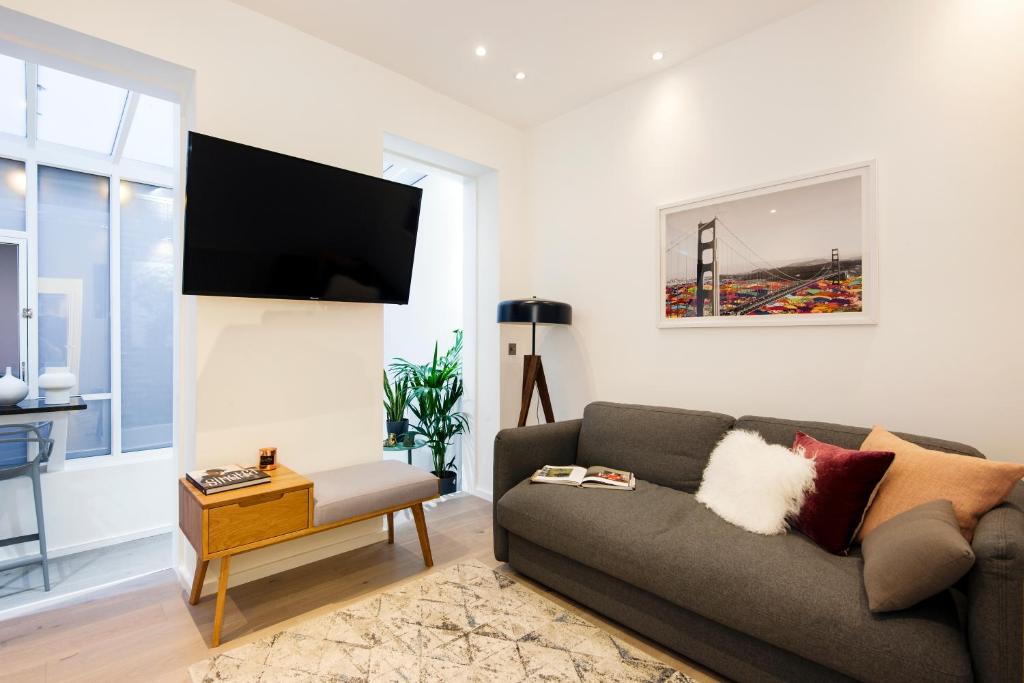 a living room with a couch and a flat screen tv at Welcome London Seven Dials in London