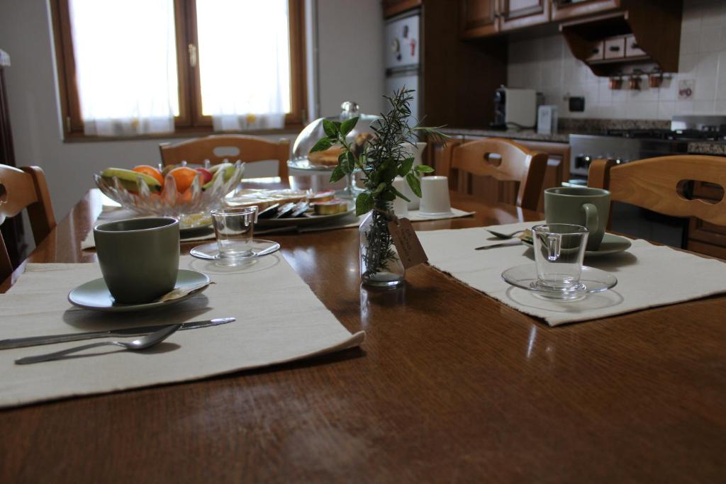 una mesa de madera con platos y cuencos de comida. en B&B Ca' Teonghio, en Orgiano