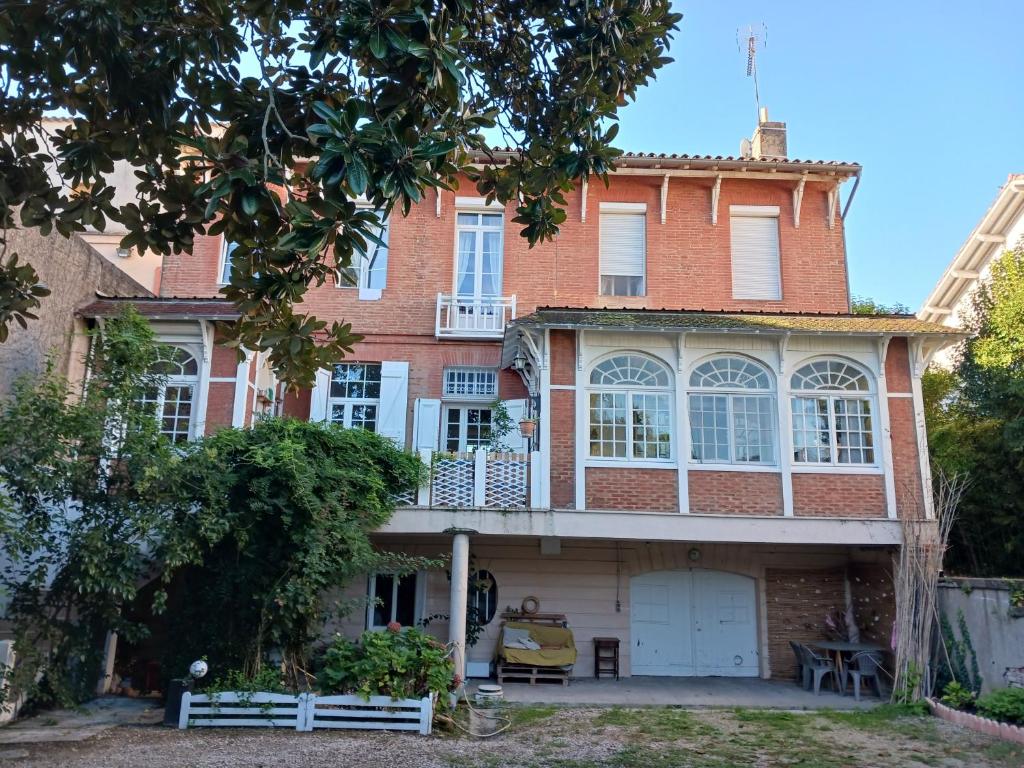 uma imagem de uma casa de tijolos com uma varanda em Vanille Bourbon em Montauban