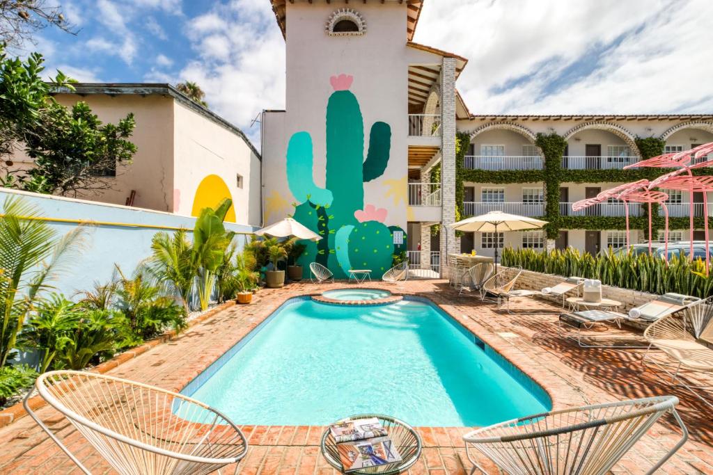 a resort with a pool and chairs and a building at Beach House by ULIV in Ensenada