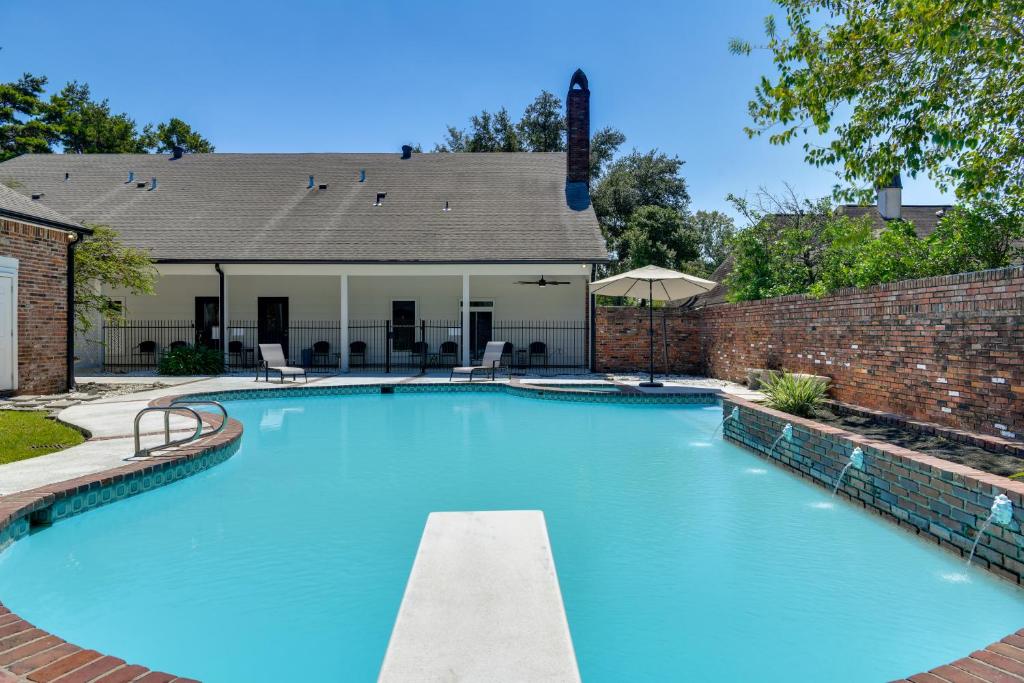 a large swimming pool with a brick wall at Stunning Baton Rouge Home with Pool Near LSU! in Baton Rouge