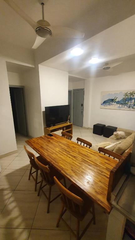 una sala de estar con una gran mesa de madera y sillas en ipanema 50m da praia com garagem, en Río de Janeiro