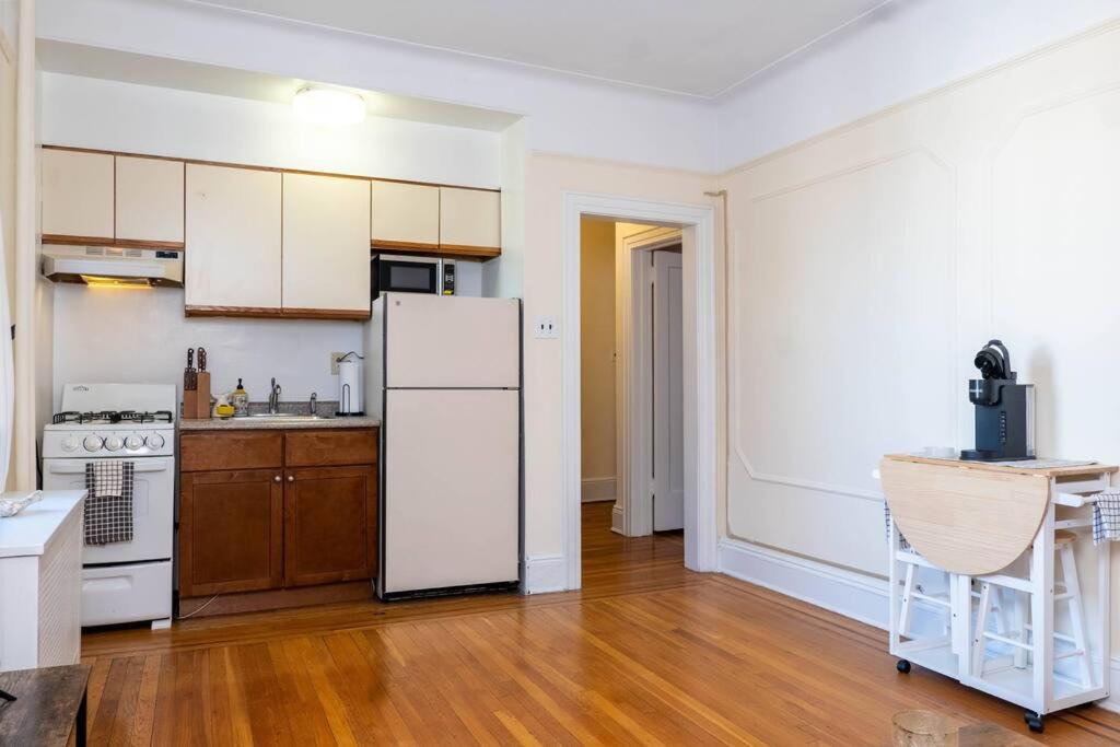 une cuisine vide avec un réfrigérateur et une table dans l'établissement Hoboken Haven – Heart of town!, à Hoboken