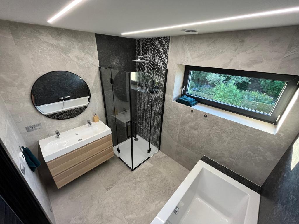 a bathroom with a sink and a shower and a mirror at Luxury VIP Villa 230m2+Pool 37m2 in Nové Jirny