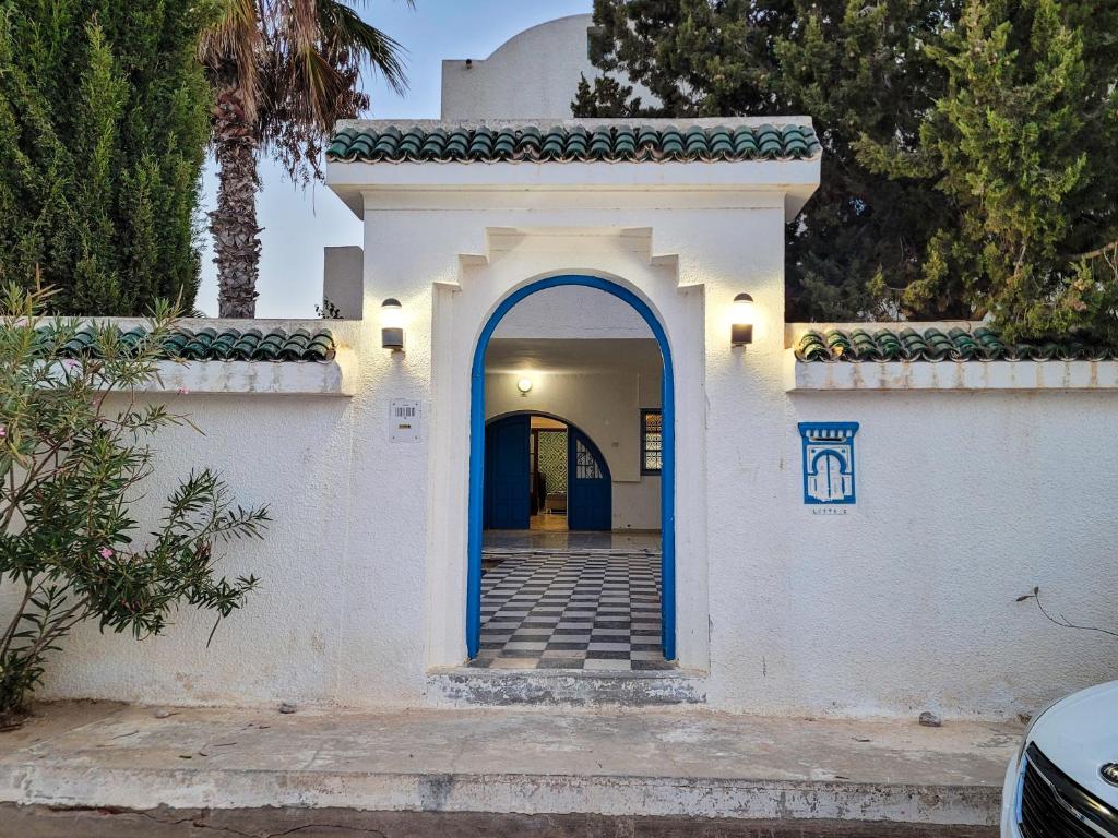 a white house with a blue doorway at Maison Nassif in Djerba