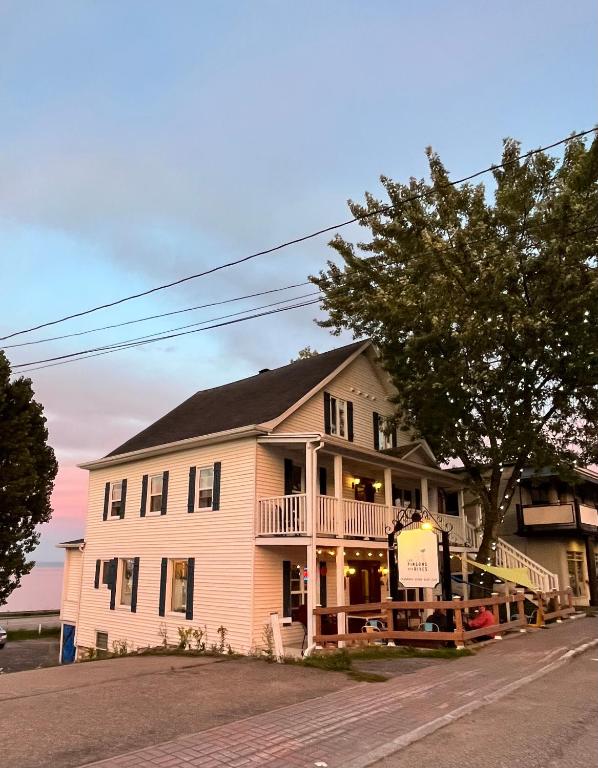 a large white house on the side of a street at Les Pinsons des Rives in La Malbaie