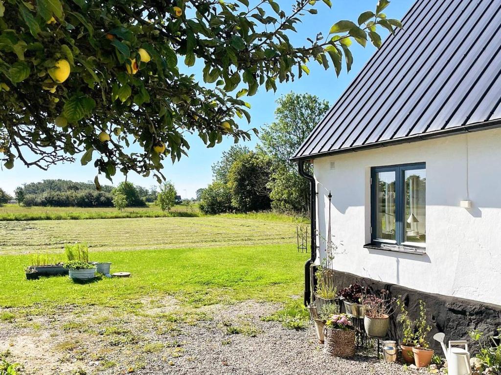 a white building with a window and a field at Holiday home Löderup V in Löderup