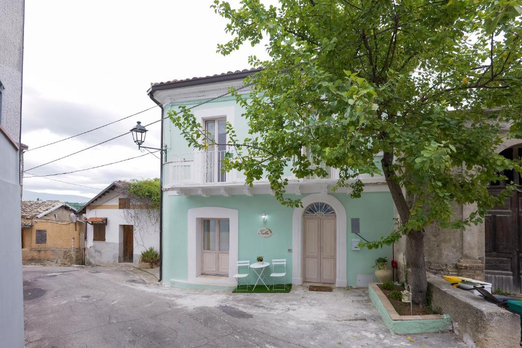 una casa azul y blanca con un árbol en Tullia -intera casa-, en Giuliano Teatino