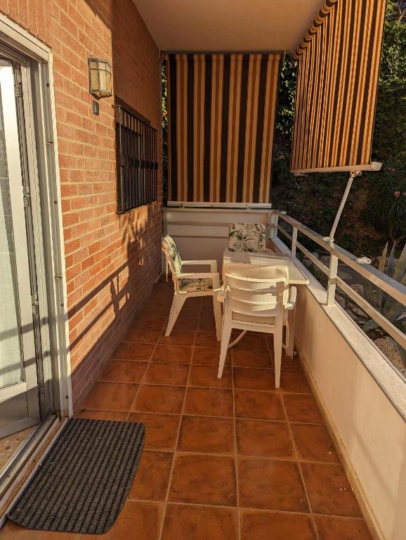 a patio with a table and chairs on a balcony at Europa Club Apartment, La Cala de Finestrat, Benidorm, Next to the beach, Ground floor, Air Cond in Benidorm