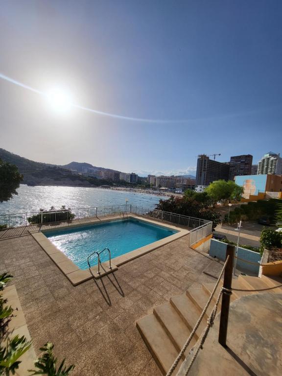 a swimming pool with a view of a body of water at Europa Club Apartment, La Cala de Finestrat, Benidorm, Next to the beach, Ground floor, Air Cond in Benidorm