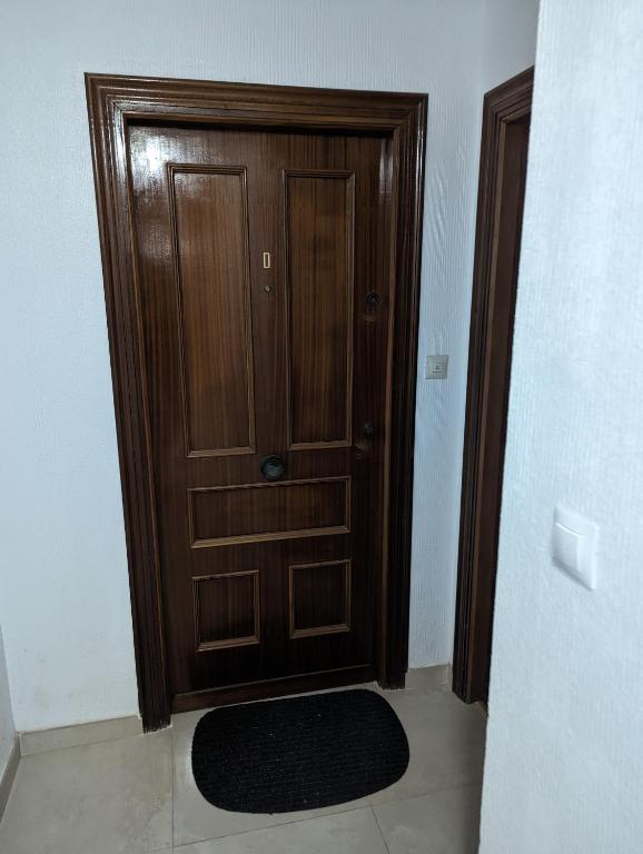 a wooden door with a rug in front of it at Europa Club Apartment, La Cala de Finestrat, Benidorm, Next to the beach, Ground floor, Air Cond in Benidorm