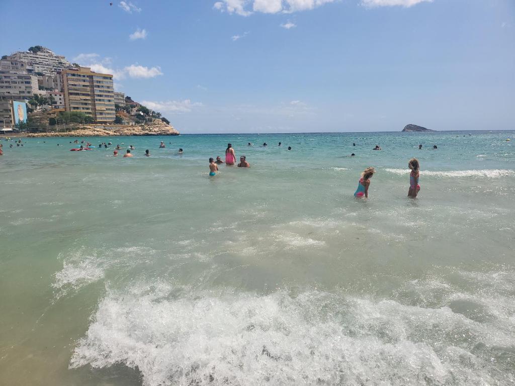 a group of people in the water at the beach at Europa Club Apartment, La Cala de Finestrat, Benidorm, Next to the beach, Ground floor, Air Cond in Benidorm