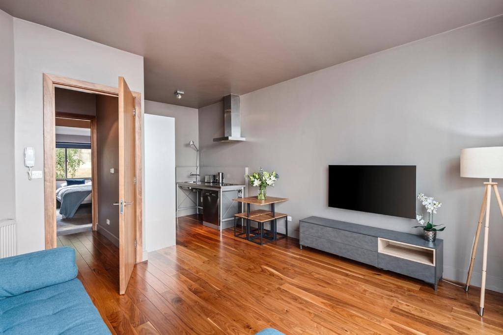 uma sala de estar com um sofá azul e uma televisão de ecrã plano em Modern Spacious Apartment in Islington em Londres