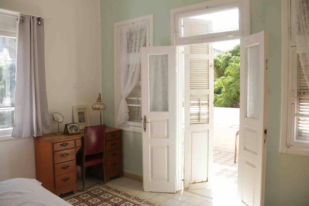a bedroom with a door open to a bedroom with a desk at Lily’s house in Haifa