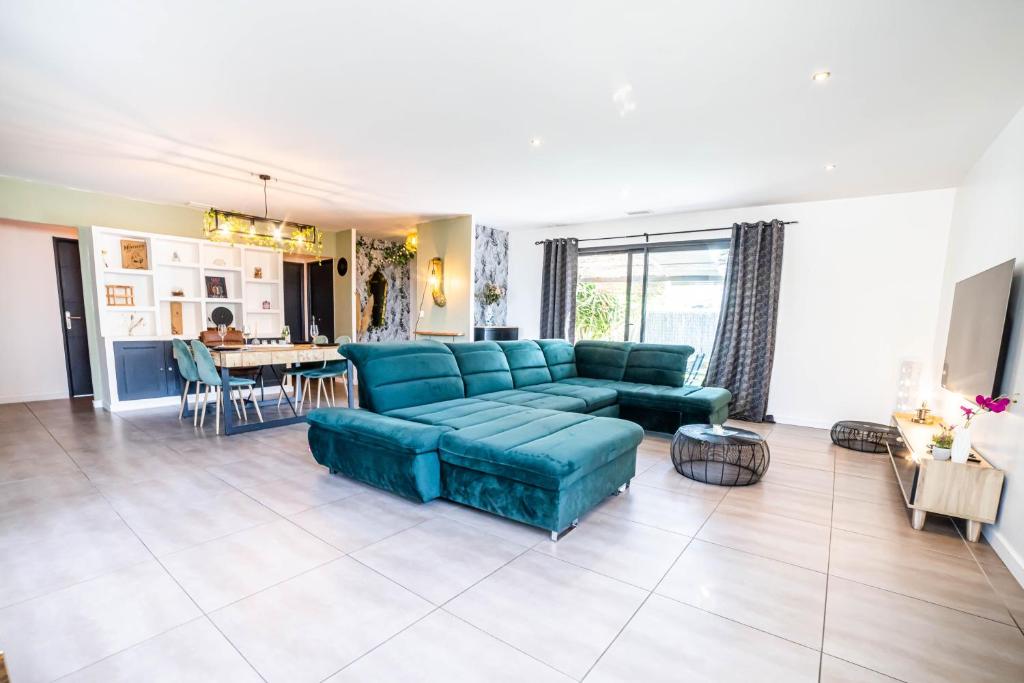 uma sala de estar com um sofá azul e uma mesa em New Villa Oasis- Clim- Piscine privé- Cosy- famille TOP PROS SERVICESCONCIERGERIE em Saint-Gély-du-Fesc