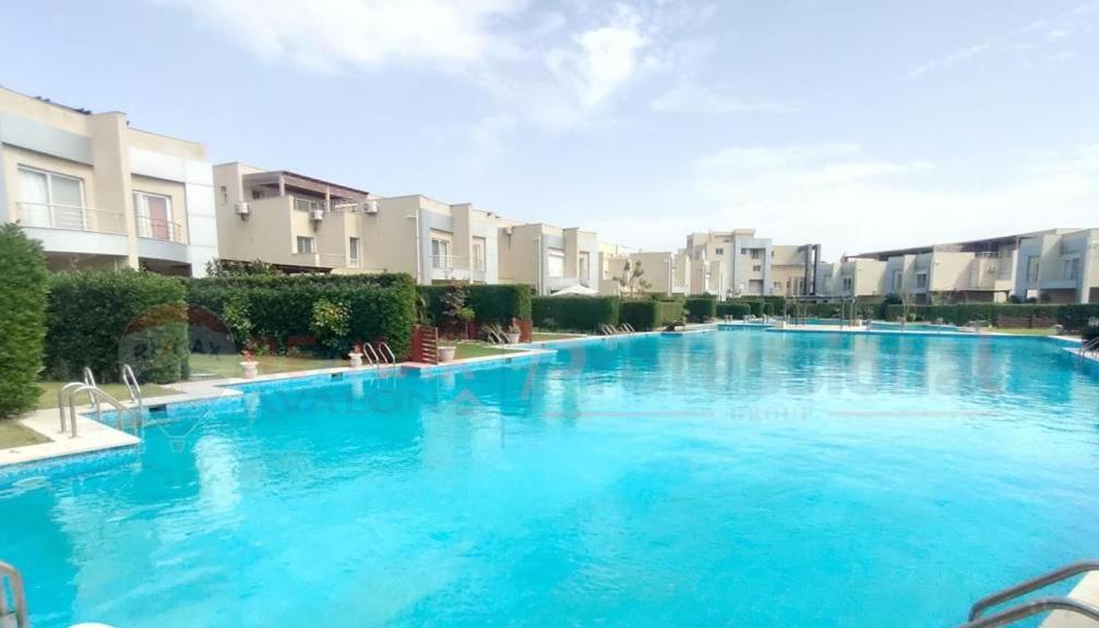 una gran piscina azul con edificios en el fondo en North coast Sedra resort villa قرية سيدرا الساحل الشمالي, en Alejandría