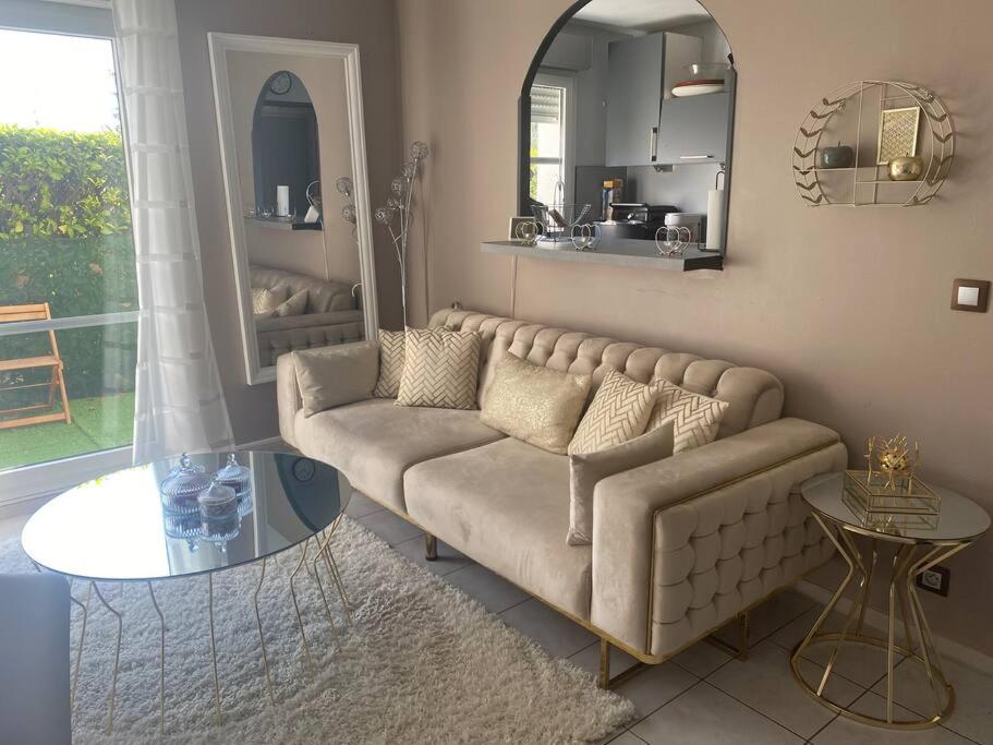 un soggiorno con divano e specchio di Cosy appart proche du rer A et psa a Carrières-sous-Poissy