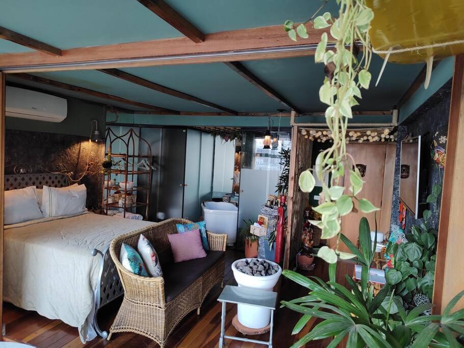 um quarto com uma cama e um sofá e algumas plantas em Loft Java - 1709 Mirante do Vale #sampaskay em São Paulo