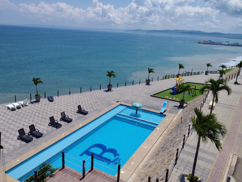 an overhead view of a swimming pool next to the ocean at Punta Blanca Beach Apartments Manta Coliving Ecuador in Jaramijó