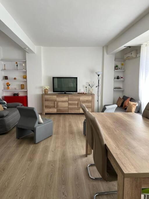a living room with a table and a flat screen tv at Le building: 5 pax centre ville in Marseille