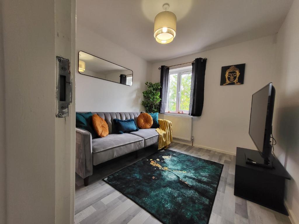 a living room with a couch and a television at Stylish Flat - Great location for Contractors, Families, Relocators, Business, Free Parking, Long-Stays in Banbury