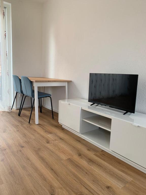 una sala de estar con TV en un armario blanco en Wohnung in Betzingen, en Reutlingen