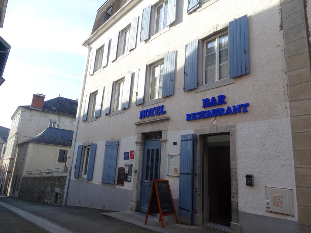 um edifício branco com persianas azuis numa rua em Hotel de la poste em Tardets-Sorholus