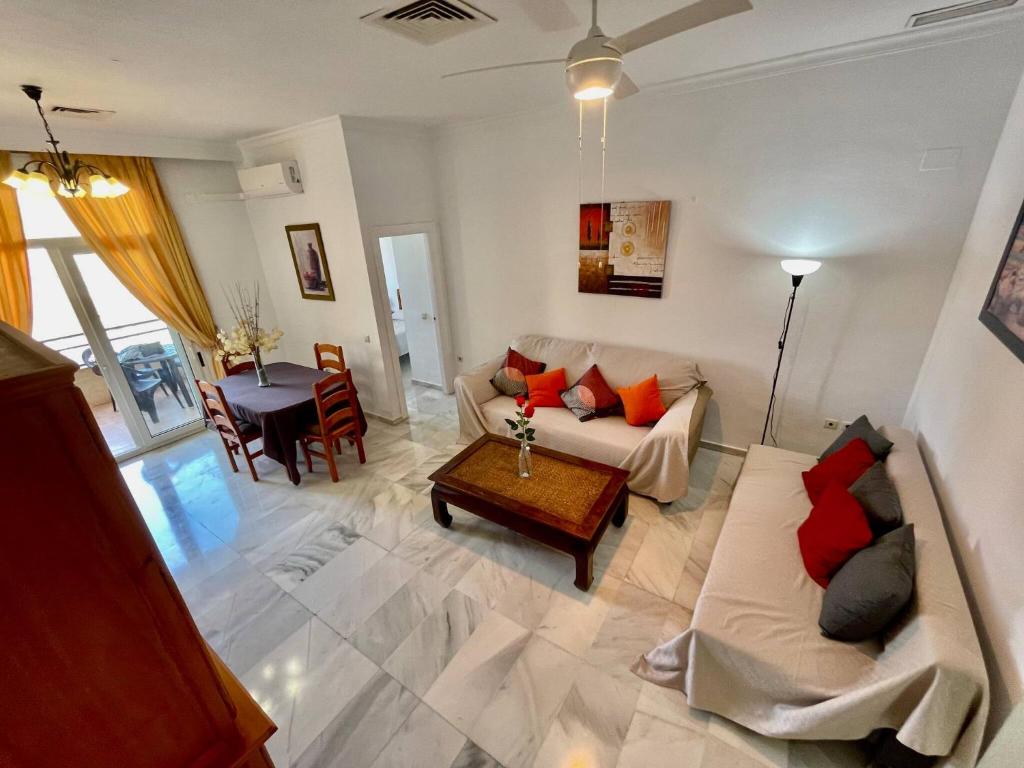 a living room with a couch and a table at El Coloso de SteraM Flats Benalmádena in Benalmádena