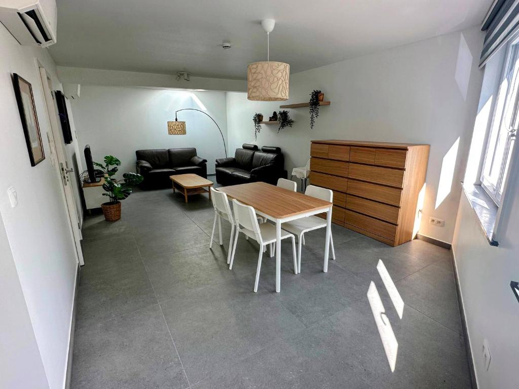 uma sala de estar com uma mesa e um sofá em Akuta City Flat Leuven em Lovaina