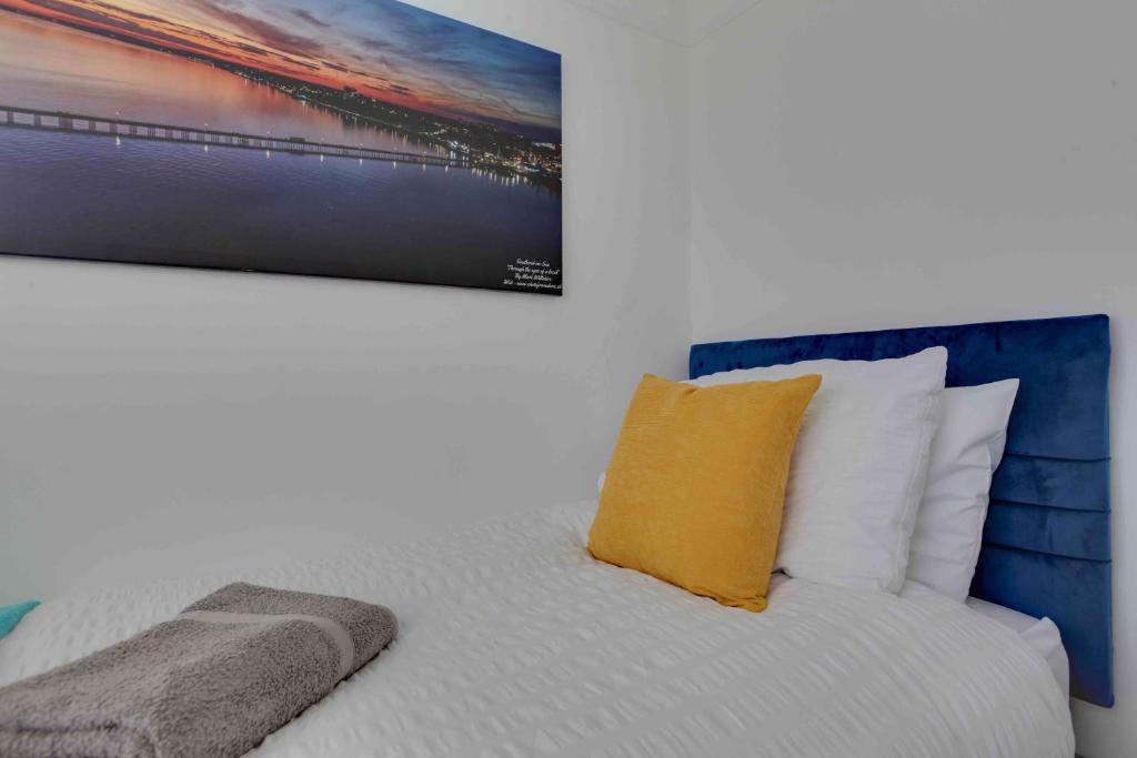 una camera da letto con un letto e un dipinto sul muro di Grove House Southend on Sea a Southend-on-Sea
