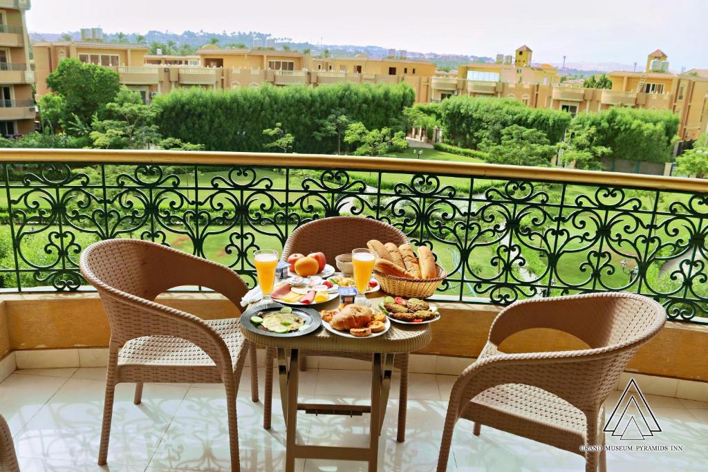 uma mesa com comida e bebidas numa varanda em Grand Museum Pyramids Inn em Giza