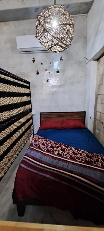 a bedroom with a bed and a chandelier at YAXCHILAN 27 in Cancún