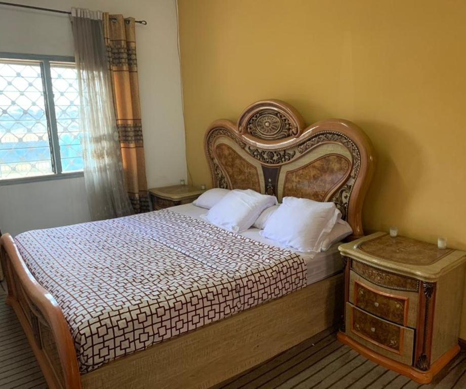una camera con un grande letto e una finestra di VILLA ÉMERAUDE a Yaoundé